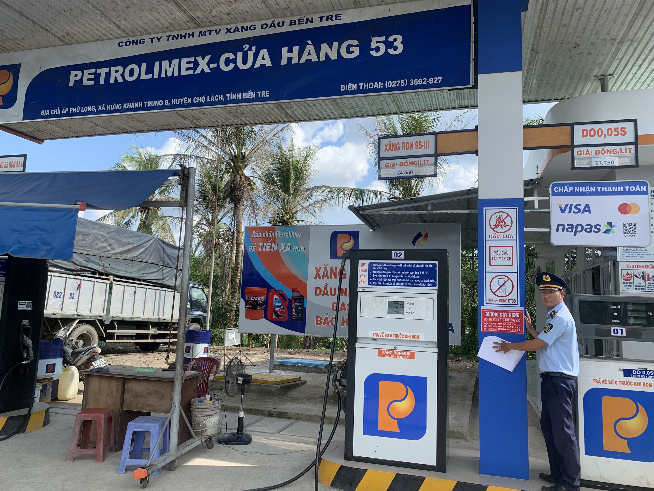 Đội QLTT số 2 dán số điện thoại đường dây nóng tại một cửa hàng kinh doanh xăng dầu ở xã Hưng Khánh Trung B, huyện Chợ Lách