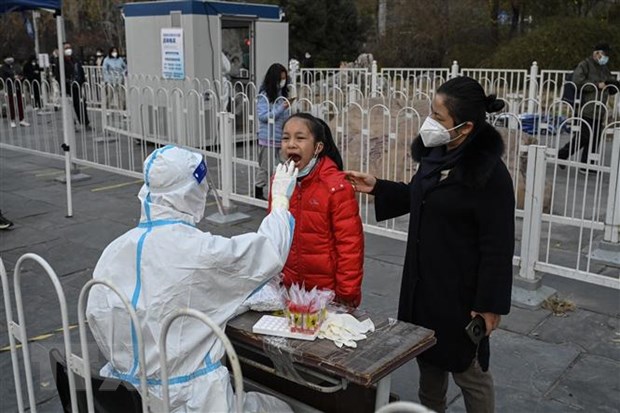 Nhân viên y tế lấy mẫu xét nghiệm COVID-19 cho người dân tại Bắc Kinh, Trung Quốc, ngày 22/11/2022. (Ảnh: AFP/TTXVN)