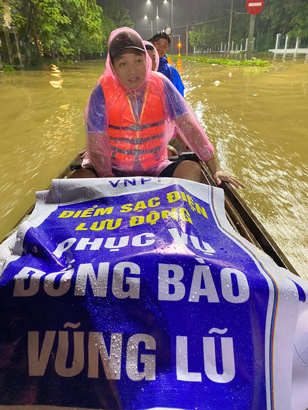 Nhân viên VNPT bơi xuồng đem máy móc đến các khu vực bị mất điện để phục vụ nhu cầu sạc điện, kết nối thông tin của người dân 