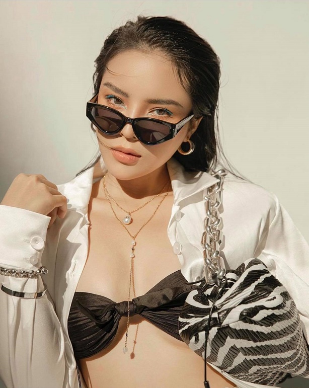 Hình ảnh mới nhất của Hoa hậu Việt Nam 2014 cho thấy vẻ nóng bỏng, gợi cảm trong set đồ trắng đơn giản nhưng không đơn điệu bởi điểm nhấn là chiếc bra màu đen hờ hững không đủ che hết vòng 1 săn, kết hợp với túi xách họa tiết ngựa vằn của Bottega Veneta.