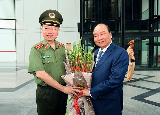Bộ trưởng Tô Lâm tặng hoa chào mừng Thủ tướng Chính phủ Nguyễn Xuân Phúc đến dự và phát biểu chỉ đạo tại Hội nghị 