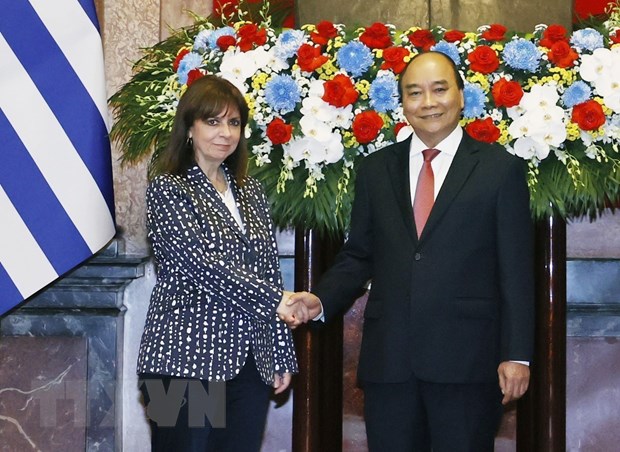 Chủ tịch nước Nguyễn Xuân Phúc và Tổng thống Hy Lạp Katerina Sakellaropoulou chụp ảnh chung tại lễ đón. (Ảnh: Thống Nhất/TTXVN)