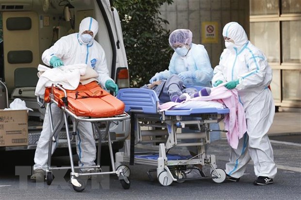 Nhân viên y tế chuyển bệnh nhân COVID-19 tới bệnh viện ở Tokyo, Nhật Bản. (Ảnh: Kyodo/TTXVN)