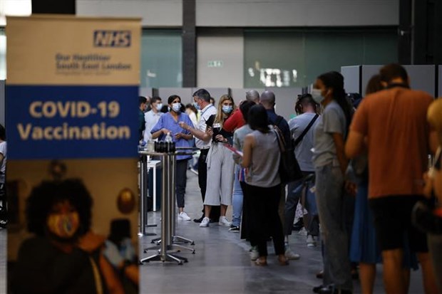 Người dân xếp hàng chờ tiêm vaccine ngừa COVID-19 tại London (Anh). (Ảnh: AFP/TTXVN)