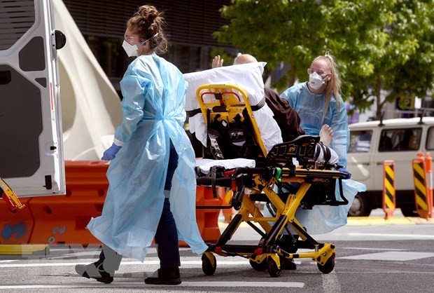 Nhân viên y tế chuyển bệnh nhân COVID-19 tại bệnh viện ở Melbourne, Australia. (Ảnh: AFP/TTXVN)