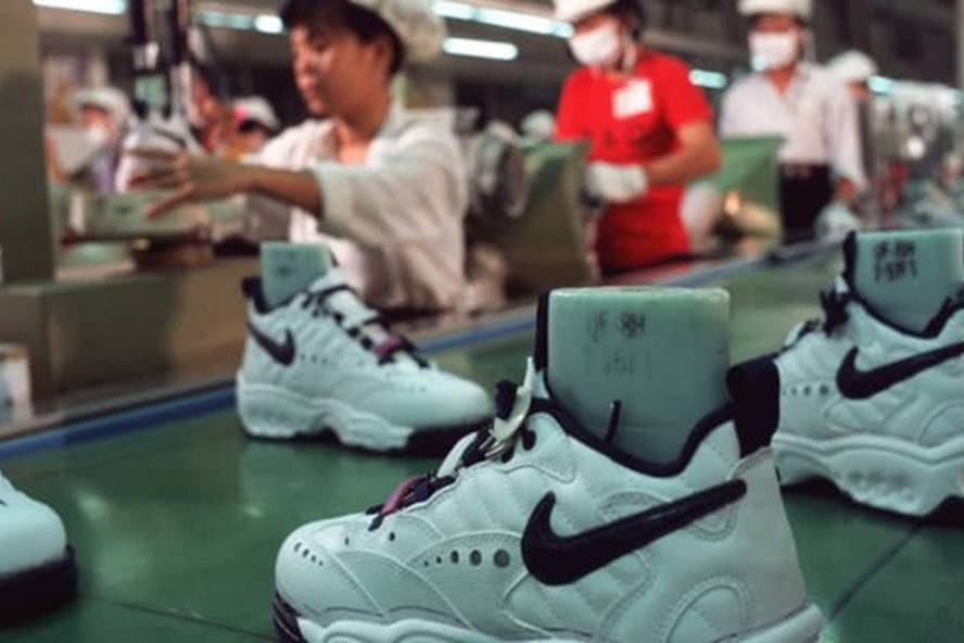 Công nhân của một nhà máy Nike làm việc tại một dây chuyền sản xuất băng chuyền, đóng giày thể thao Nike. (Ảnh minh họa - Ảnh: Getty Images)