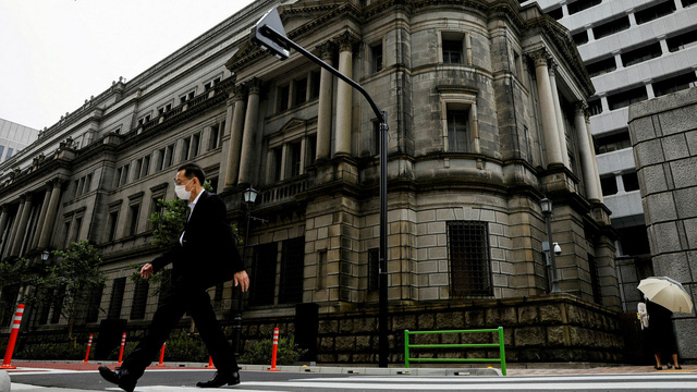Một người đàn ông đi ngang qua trụ sở Ngân hàng Trung ương Nhật Bản (BOJ) ở Tokyo. (Ảnh: Reuters)