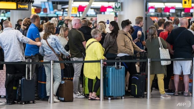 Những hàng dài hành khách đợi bên ngoài sảnh vào sân bay Schiphol ở Hà Lan. (Nguồn: AFP)