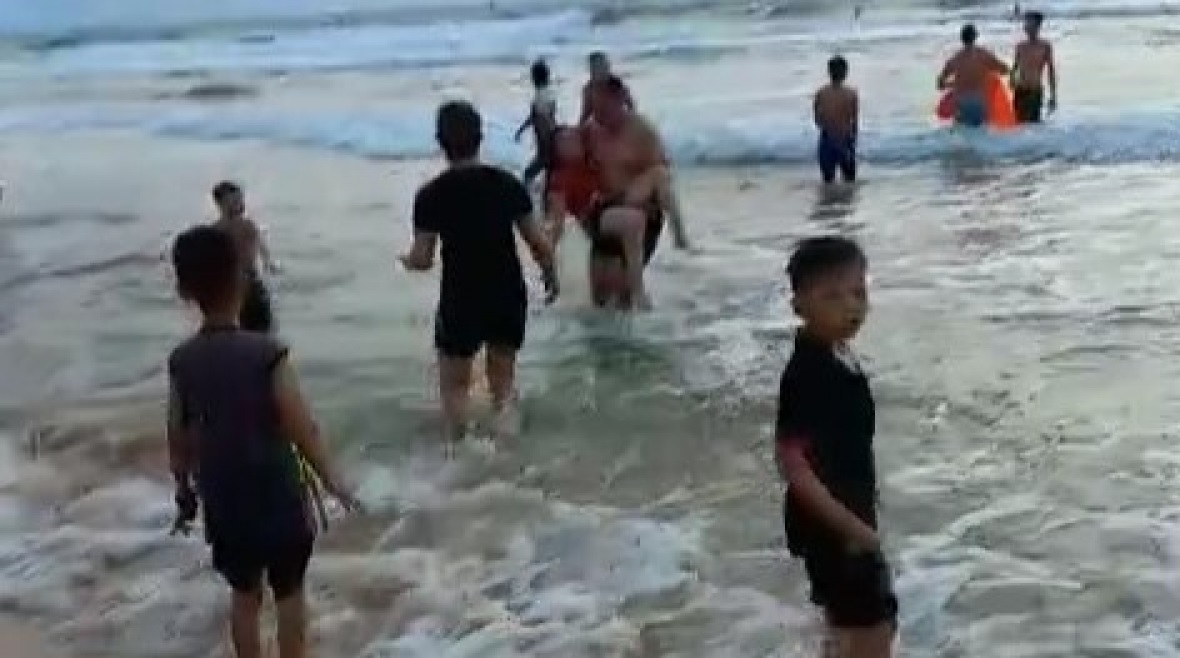 Người dân tham gia cứu các nạn nhân bị đuối nước đưa vào bờ (ảnh cắt từ clip)