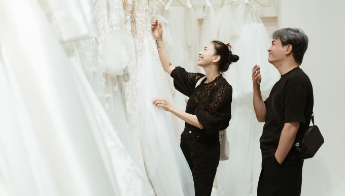 Chuyên viên trang điểm Nam Trung (phải) giúp Ngô Thanh Vân chọn váy cưới. Ảnh: VAA Agency