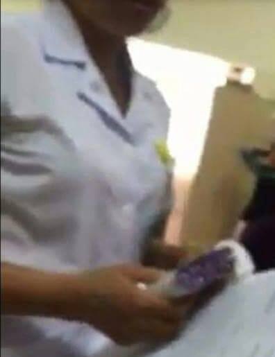 Nhân viên bệnh viên K nhận phong bì (Ảnh được cắt ra từ clip)