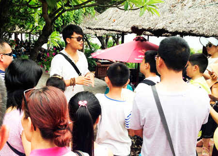 Một người Trung Quốc làm hướng dẫn viên du lịch “chui” tại danh thắng Hòn Chồng, TP. Nha Trang.