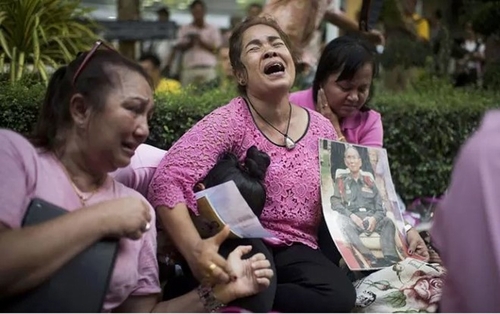 Người dân khóc thương sau khi nghe tin Vua Bhumibol Adulyadej băng hà. Trước khi thông tin này được công bố, họ mặc áo hồng, tụ tập trước bệnh viện để cầu nguyện cho quốc vương sớm khỏe lại. Ở Thái Lan, màu hồng được coi là màu sắc mang lại may mắn. Ảnh: Getty.