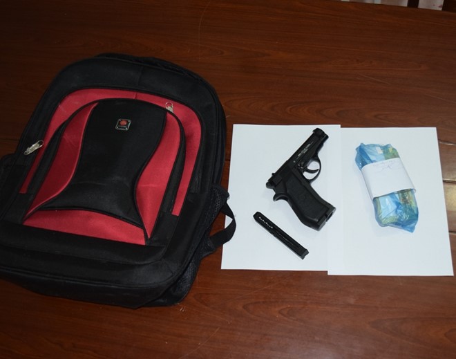 Túi xách và khẩu súng của nghi phạm cướp ngân hàng ở Huế. Ảnh: 