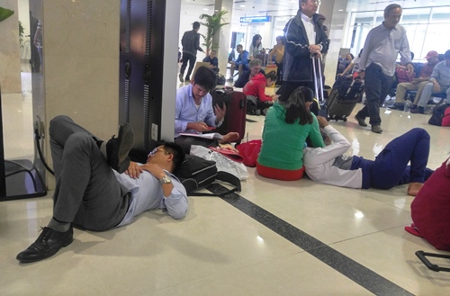 Hành khách nằm, ngồi vạ vật bên trong sân bay vì hoãn chuyến, đổi giờ bay