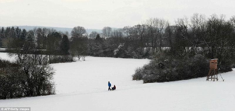 Người dân dùng xe kéo di chuyển trong địa hình bị tuyết phủ dày ở thị trấn Eichenau, miền nam Đức. Ảnh: AFP.