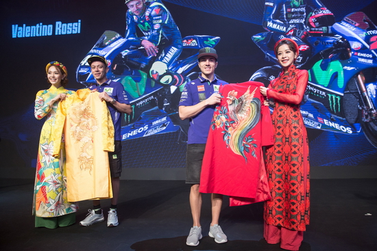 Chi Pu cùng Minh Hằng trao hoa và quà là hai chiếc áo dài cho hai tay đua hàng đầu thế giới. Cả Rossi lẫn Viñales đều bất ngờ trước món quà và hào hứng khi được hai ngôi sao giúp mặc trang phục truyền thống Việt Nam.