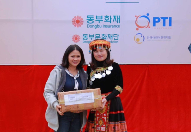Bà Trần Bích Hợp - Đại diện Tổng Công ty Bảo hiểm Bưu điện (PTI) trao quà tại trường THCS Nùng Nàng.