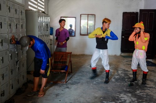 Những nài ngựa chuẩn bị trang phục ra sân tập. Phần lớn họ đến từ trường đua Phú Thọ (TP HCM) trước đây, với tuổi đời 18-30.