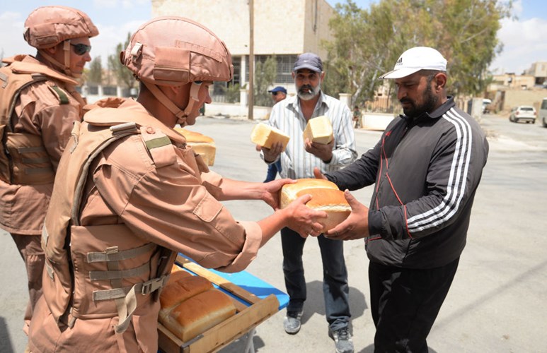 Các binh sỹ Nga ở Syria phân phát bánh mì cho người dân ở Palmyra. Ảnh Sputnik