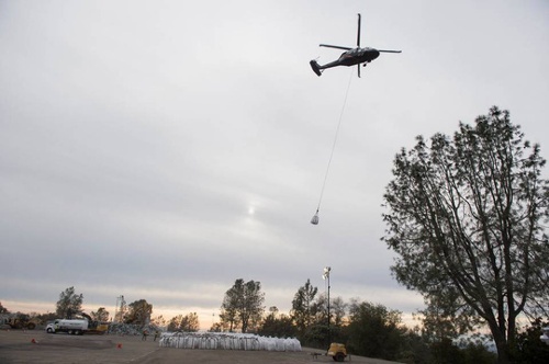 Máy bay trực thăng và xe tải đổ 1.200 tấn đá/ giờ xuống khu vực bị xói mòn.