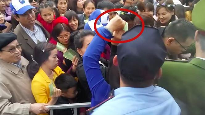 Phụ nữ áo đen và áo xanh tranh cướp vé (vòng tròn đỏ) gây hỗn loạn tại lễ hội hoa ở Hà Nội /// Ảnh Minh Chiến