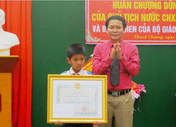 Ông Nguyễn Thanh Nhàn trao Huân Chương Dũng Cảm của Chủ  tịch nước cho em Lô Dương Tú . Ảnh: NTV.