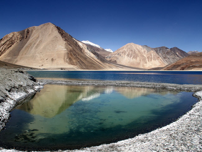 Pangong Tso là hồ kéo dài gần 100km từ Ấn Độ tới Trung Quốc và là một trong những những hồ lớn nhất ở châu Á. Với mặt nước trong xanh phản chiếu phong cảnh núi non xunh quanh, hồ trở thành địa điểm du lịch hấp dẫn.