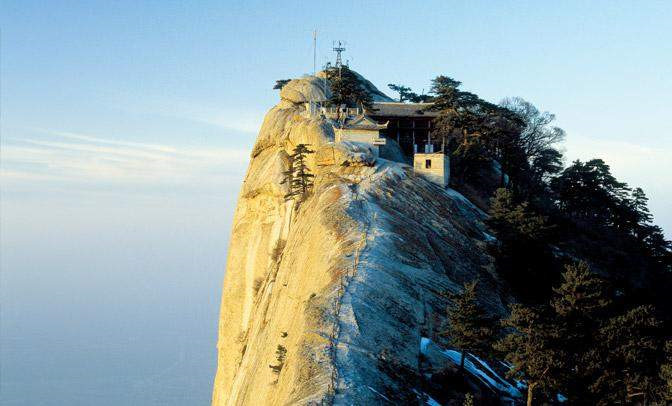 Quán trà trên đỉnh Hoa Sơn, Thiểm Tây, Trung Quốc: Để tới được đây, du khách phải bám vào dây xích, men theo con đường hiểm trở bằng ván gỗ chỉ vừa đặt chân trên bờ vực thẳm. Sau đó, bạn còn phải đi qua một cầu thang dốc tạc vào đá. Ảnh: Tripfreaks.