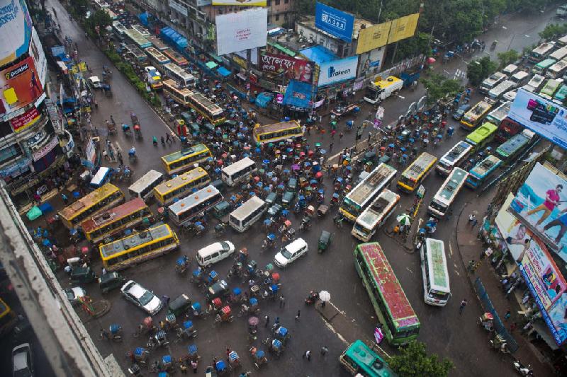 Thành phố Dhaka có khoảng 14,5 triệu dân. Bức ảnh chụp lại đường phố khi trời mưa, xe bus cố gắng chen khỏi đám đông.