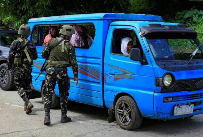 Binh lính kiểm tra giấy tờ tùy thân của người sơ tán ở thành phố Marawi, lục soát để xem có bom hay vũ khí giấu trong xe hoặc mang theo người hay không. Ảnh: 