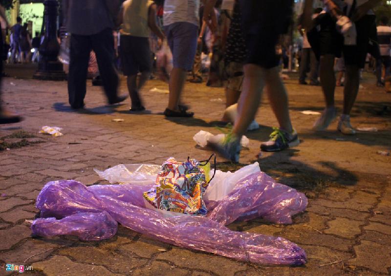 Người đi đường không mấy bận tâm đến rác thải dưới chân. Họ cứ thản nhiên bước đi trên phố.