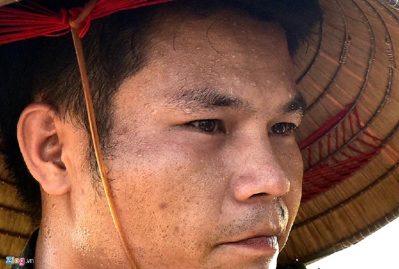 Mồ hôi chảy dòng dòng trên khuôn mặt của một than niên khi gặt lúa dưới nắng nóng tại cánh đồng làng Ngọc Than (Ngọc Mỹ, Quốc Oai, Hà Nội). Ảnh: Việt Hùng.