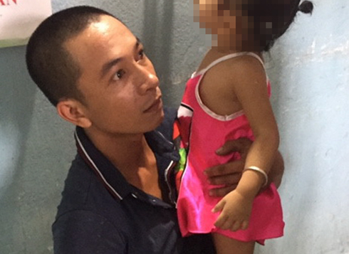 Trong khi lực lượng Công an khám nghiệm căn nhà, Việt ôm đứa con nhỏ nhất vào lòng.