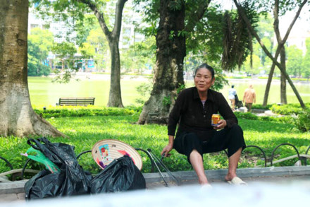 Giây phút nghỉ giải lao của người đàn bà nhặt rác trên phố đi bộ Hồ Gươm. Cụ bà từng 2 lần tay không bắt 