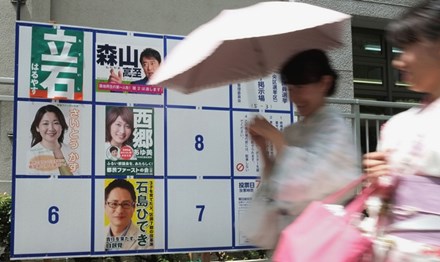 Một phụ nữ đi qua tấm bảng dán chân dung các ứng cử viên trong cuộc bầu cử quốc hội tại một điểm bỏ phiếu ở Tokyo ngày 2/7. Ảnh: Getty Images.