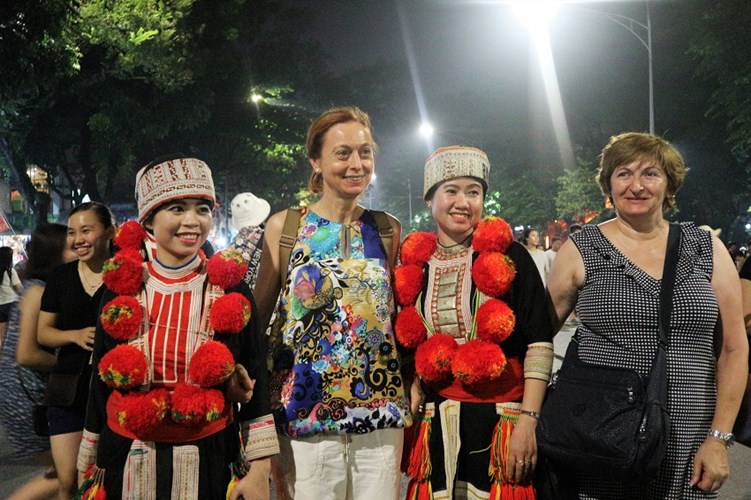 Du khách nước ngoài hào hứng chụp ảnh cùng các cô gái người Dao xinh đẹp.