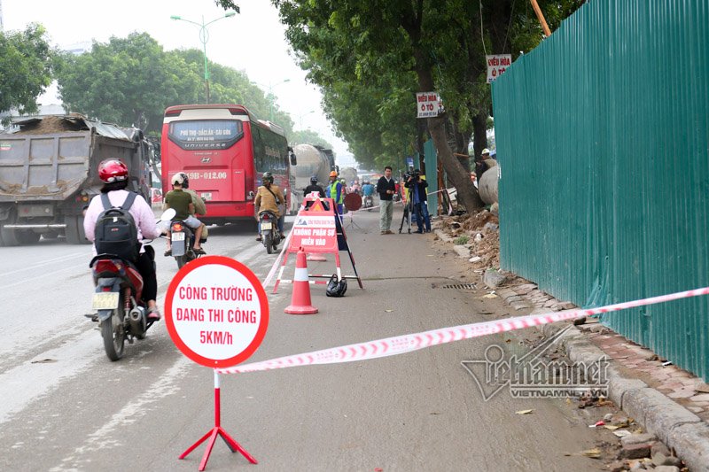 Đường Phạm Văn Đồng vốn đã rất chật hẹp, đơn vị thi công chặn một phần đường để chặt cây gây khó khăn cho các phương tiện lưu thông