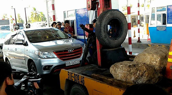 Một ôtô bị xe cẩu kéo ra khỏi làn thu phí tại BOT Cai Lậy. Ảnh: Đức Thịnh.