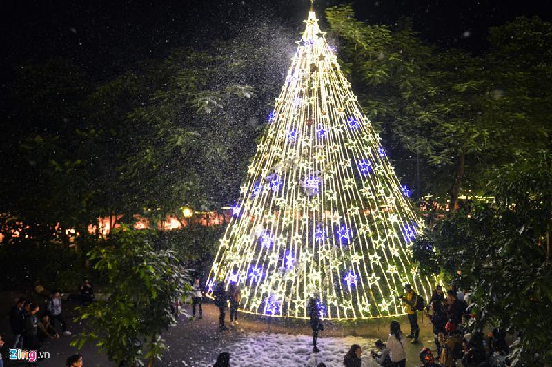 Hình ảnh cây thông Noel được trang trí đèn nhấp nháy cùng các bông tuyết trắng bay xung quanh thu hút nhiều bạn trẻ tham dự.