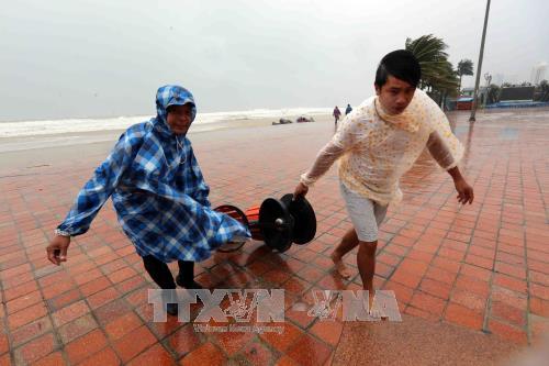Người dân thu dọn các vật dụng bị gió quật gây hư hỏng tại Công viên biển Đông (Đà Nẵng). Ảnh: Trần Lê Lâm - TTXVN