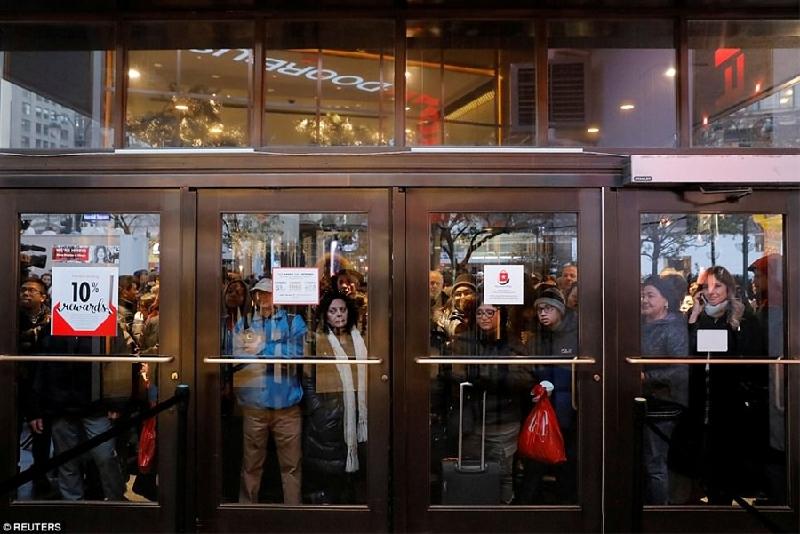 Hàng ngàn người háo hức đứng ngoài lớp cửa kính của các cửa hàng bất chấp thời tiết mùa đông lạnh giá. (Ảnh: Reuters)