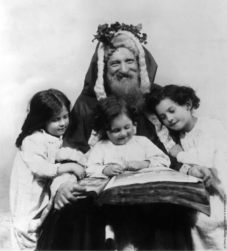 Người cha đóng giả ông già Noel đọc chuyện cho ba người con bé nhỏ dịp Giáng sinh năm 1915.
