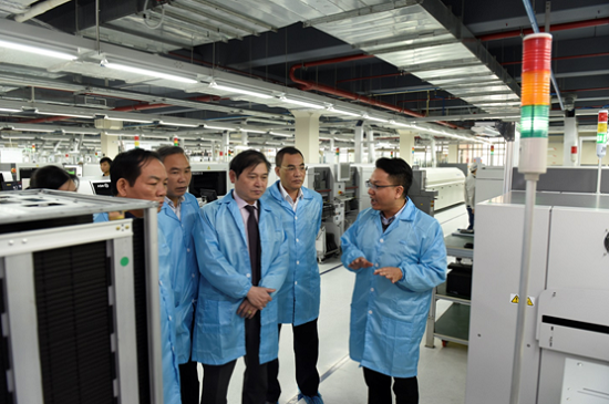 Ông Phan Xuân Dũng nghe giới thiệu về dây chuyền sản xuất của VNPT Technology tại nhà máy điện tử só 2 thuộc khu CNC Hòa Lạc.
